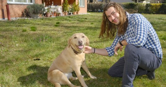 Ein Mann mit seinem Hund im Garten.
