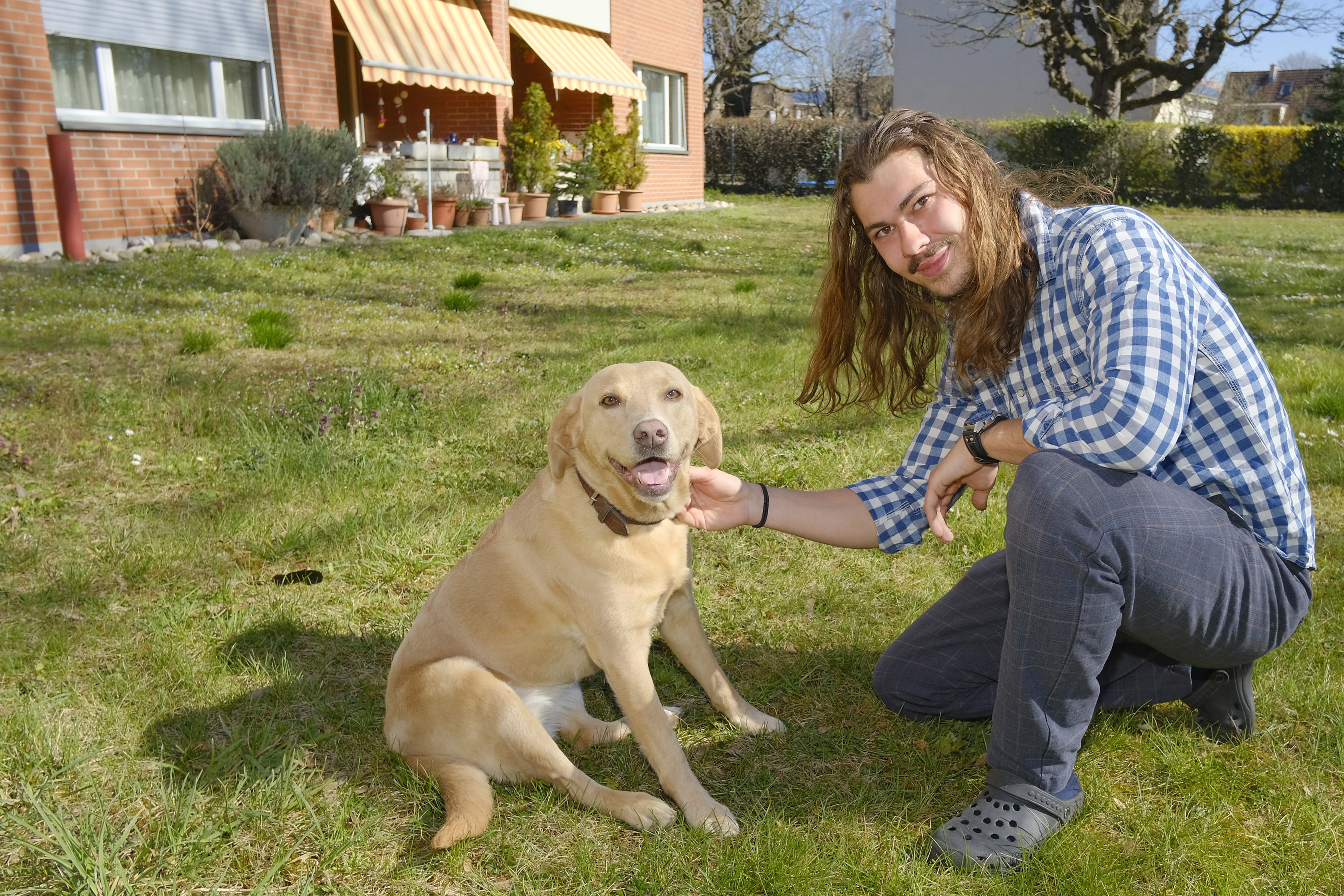 Ein Mann mit seinem Hund im Garten.