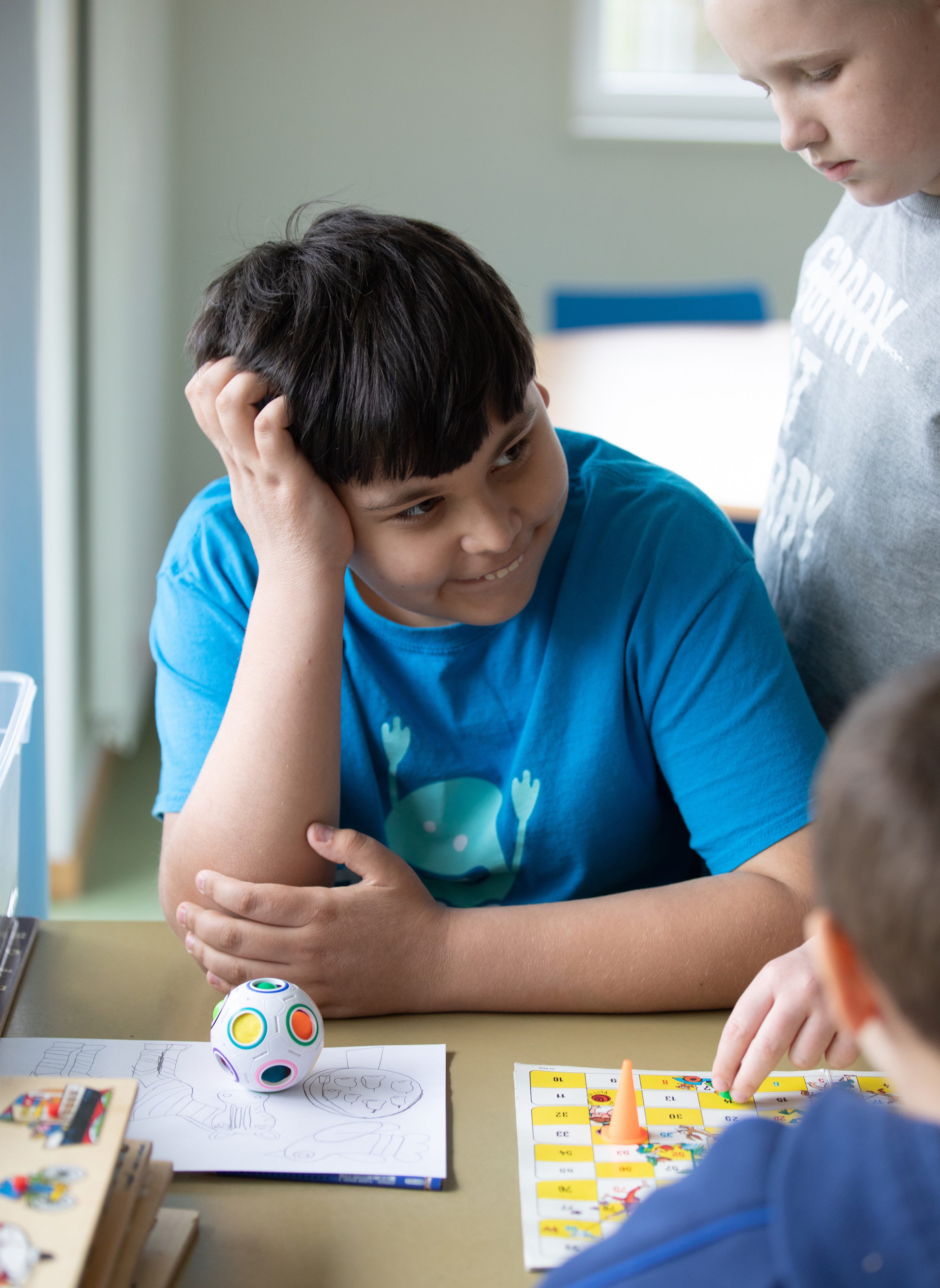 Buben am Tisch mit Spielzeug und Brettspielen_Heilsarmee