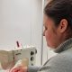 Luidmyla, Teilnehmerin am Textilprogramm Basel, arbeitet an der Nähmaschine.