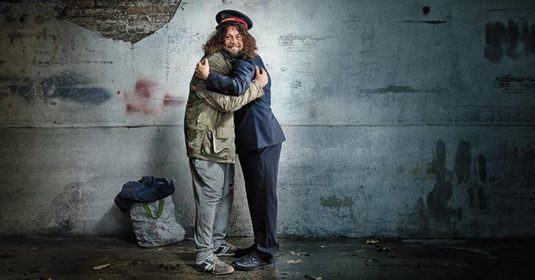 Kampagnenbild: Ein Heilsarmee-Offizier umarmt einen Menschen in einer Obdachlosigkeit