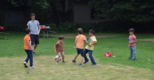 Zivildienstleistender der Heilsarmee spielt mit Kindern Fussball.