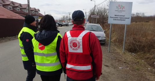 Drei Helfer der Heilsarmee stehen an der Ukrainisch-Ungarischen Grenze