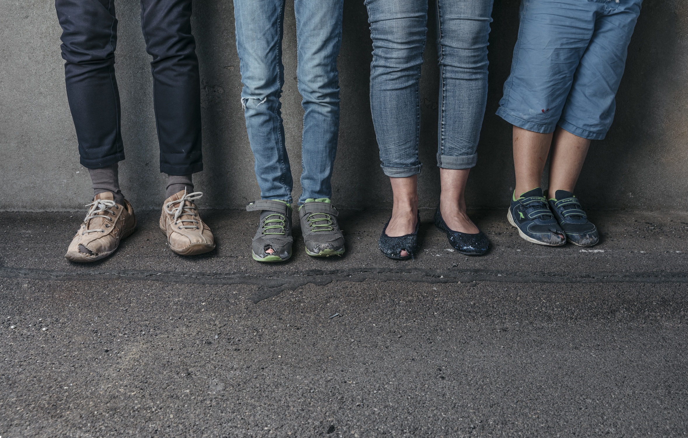 4 Paar Beine mit abgetragenen Schuhen
Vier Paar F√ºsse
